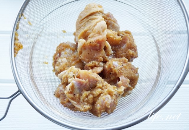 唐揚げに下味を付ける方法：フォークで漬け込みやすくしてから鶏肉をタレと揉みこむ